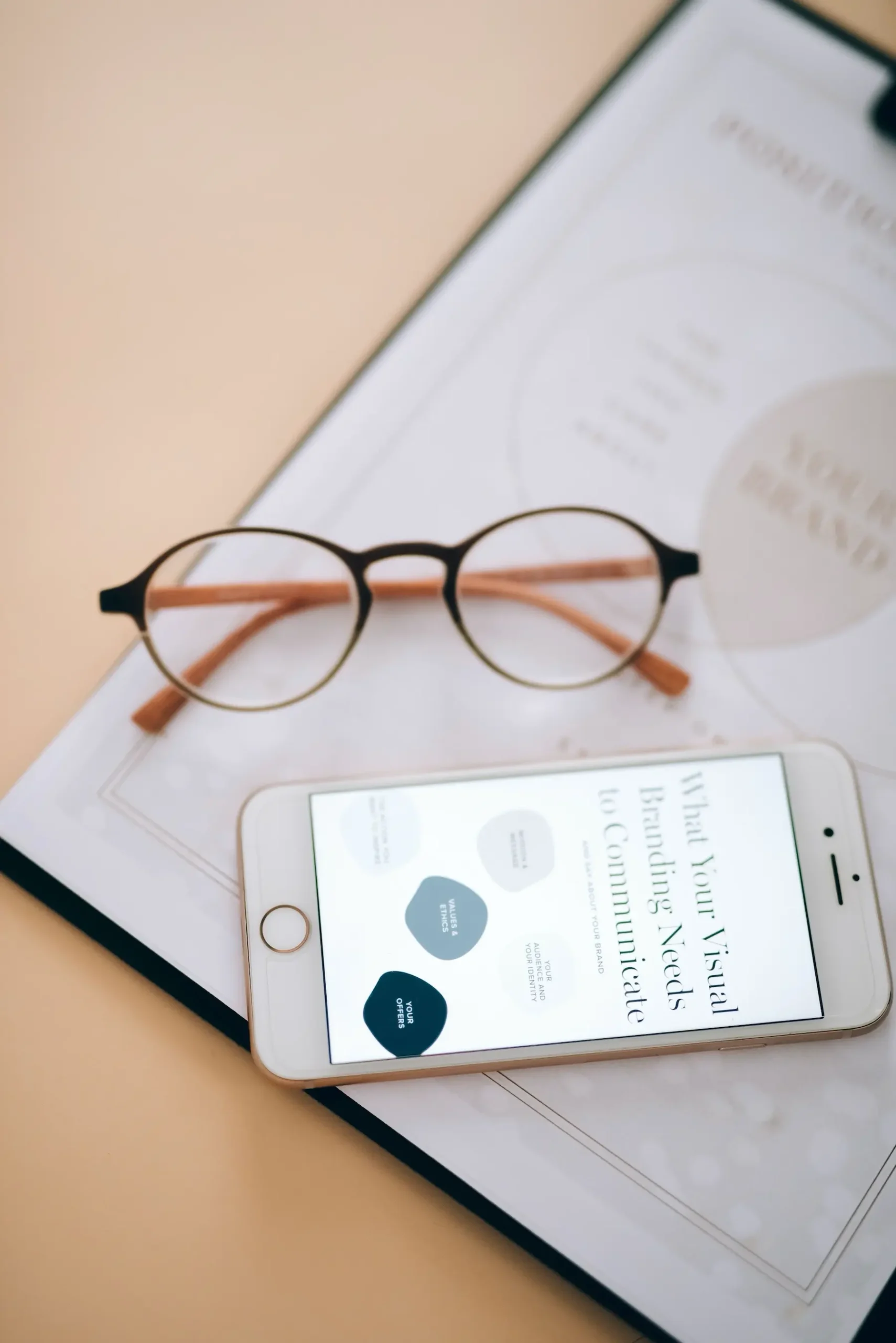Glasses and phone resting on a brand sheet
